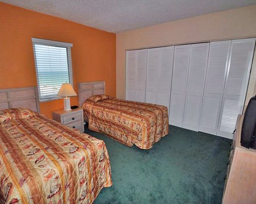 A well furnished bedroom with two twin beds and an outside view.