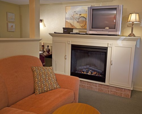 A well furnished living room with queen pull out sofa television and fireplace.