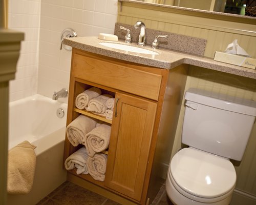 A bathroom with single sink vanity shower and bathtub.