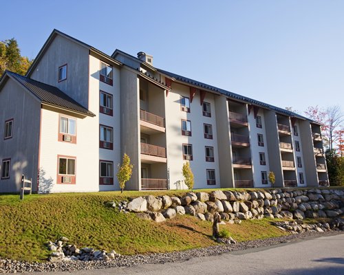 Scenic exterior view of InnSeason Resorts Pollard Brook with multiple balconies and a pathway.