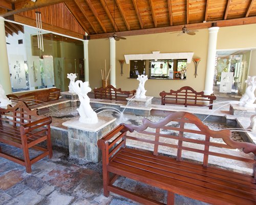 A well furnished indoor room with a pool and water features.