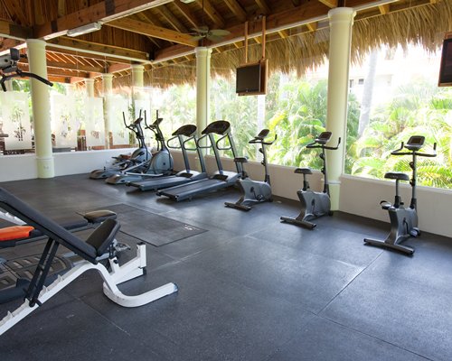 A well equipped indoor fitness center with television.
