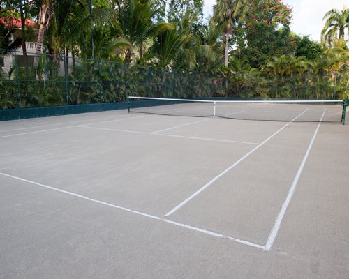 An outdoor tennis court alongside the resort unit and the trees.