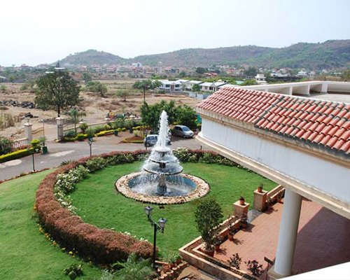 Balcony view of resort unit with a water fountain and well maintained lawn.