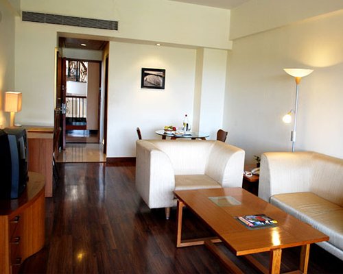 A well furnished living room with a television and dining area.