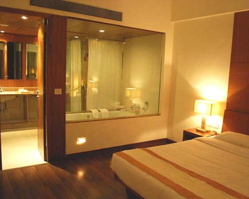 A well furnished bedroom and bathroom with shower and bathroom.