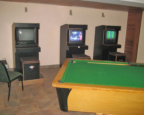 Indoor recreation room with pool table and arcade games.