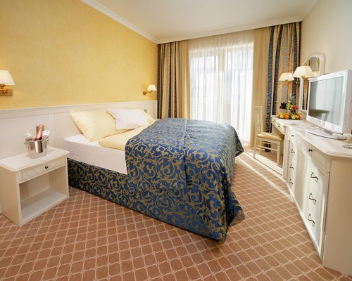 A well furnished bedroom with a television.