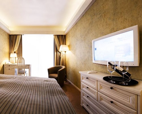 A well furnished bedroom with a television and outside view.