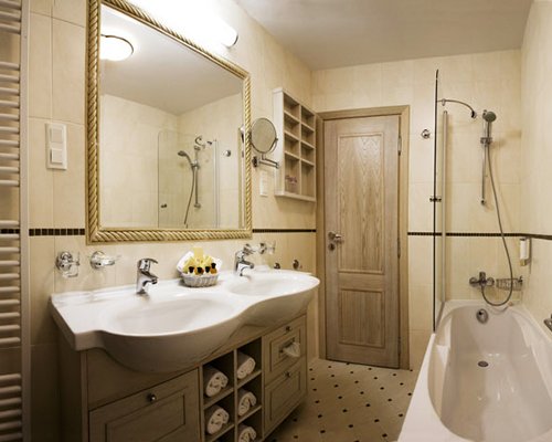 A bathroom with bathtub shower and double sink vanity.
