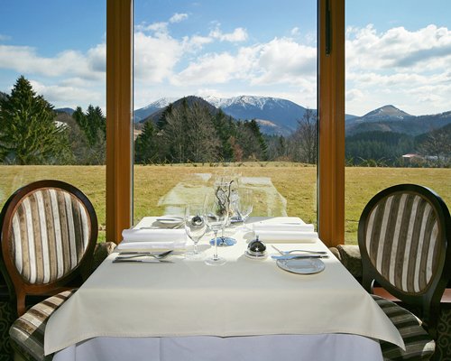 A well furnished indoor fine dining restaurant with an outside view.