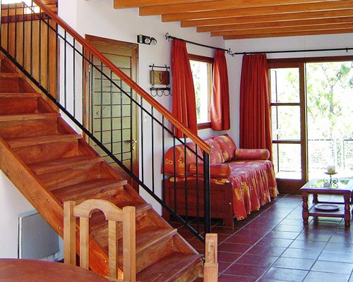 A well furnished living and dining area with a staircase and an outside view.
