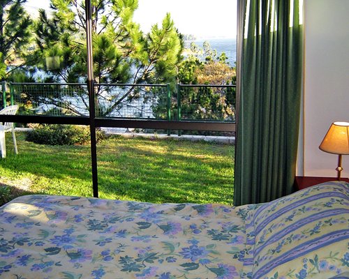 A well furnished bedroom with a lamp and the lake view.