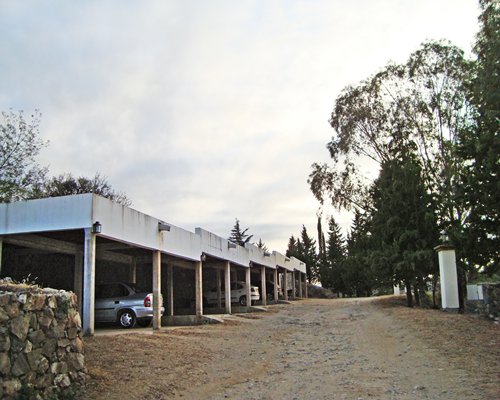 A pathway with a parking lot surrounded by a wooded area.