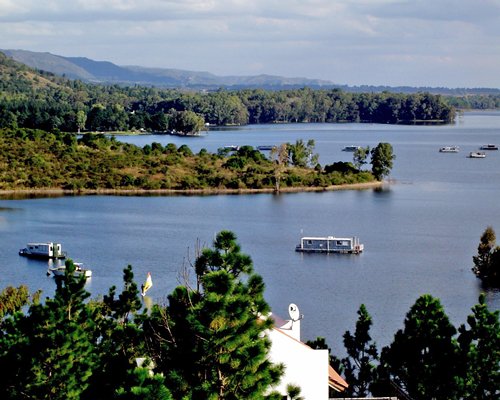 A view of the lake with boats surrounded by wooded area.