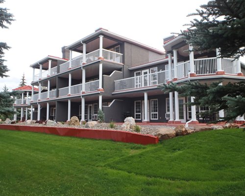 An exterior view of a multi story resort unit alongside a well maintained lawn.