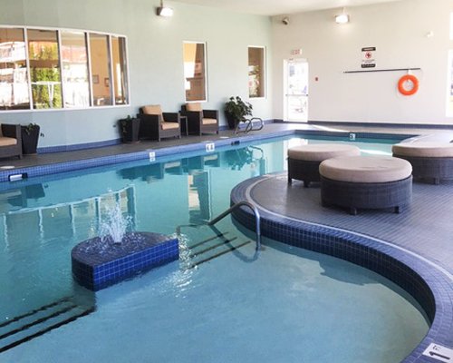 An indoor swimming pool with lounge access.