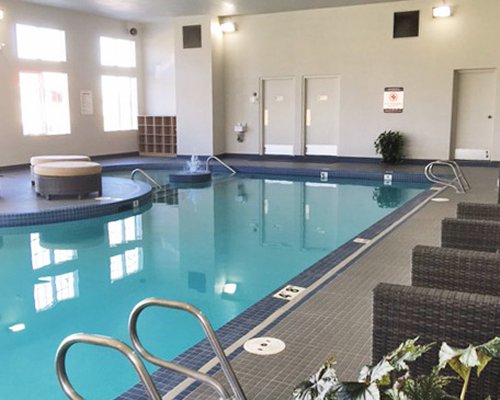 An indoor swimming pool with lounge area.