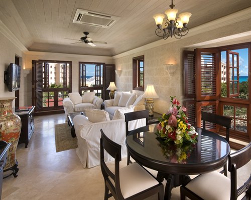 A well furnished living room with a television dining area and outside view.