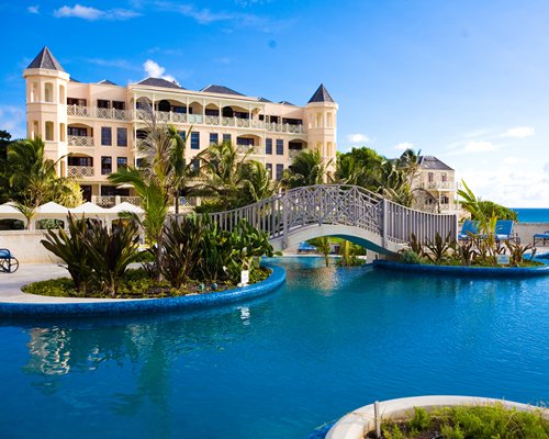 An outdoor swimming pool with bridge alongside the resort.