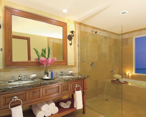 A bathroom with stand up shower bathtub and a double sink vanity.