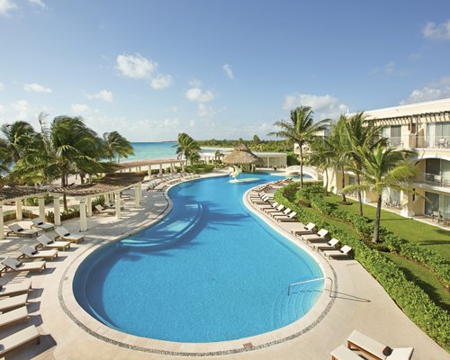 An outdoor swimming pool with chaise lounge chairs and gazebos.