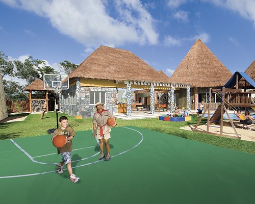 Outdoor recreation area with a basketball court alongside kids playscape.