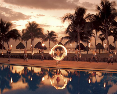 A poolside fire twirling performance at dusk.