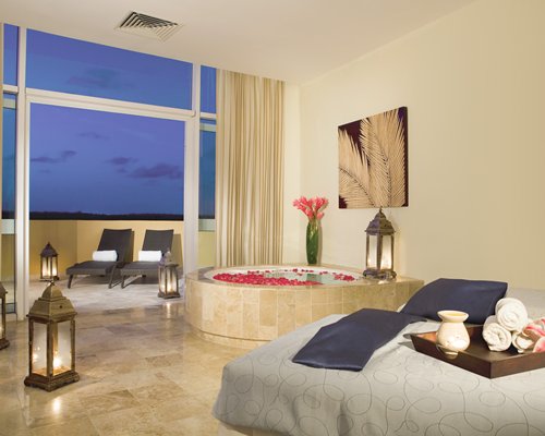 An indoor spa with a hot tub and chaise lounge chairs in the balcony.