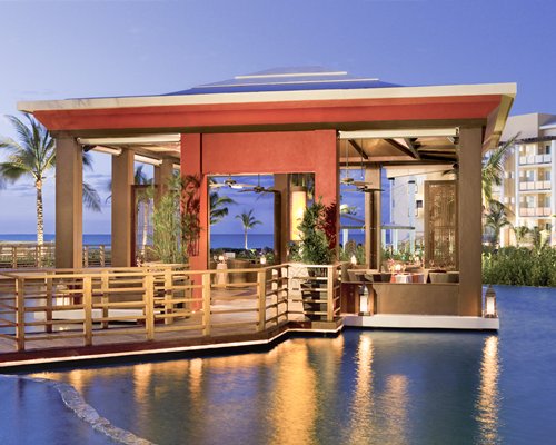 Large outdoor swimming pool with lounge area alongside the sea.