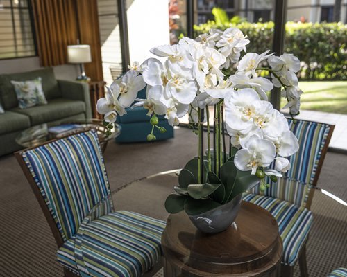A well furnished living room with a glass top dining area balcony and patio furniture.