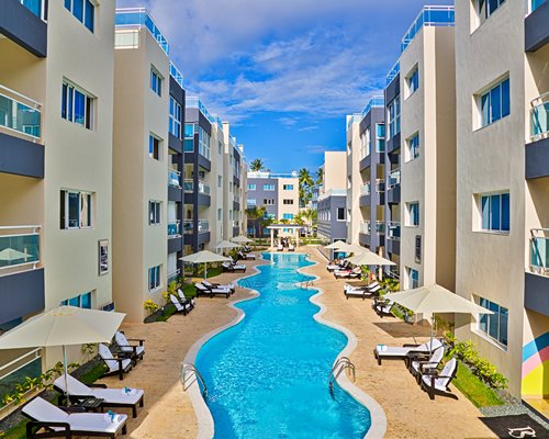 An outdoor pool alongside multi story resort units.