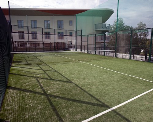 An outdoor tennis court alongside resort units.