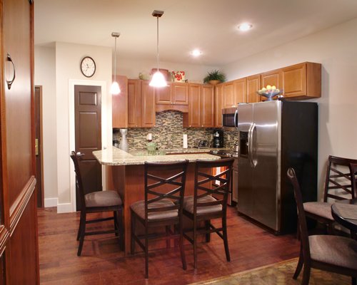 A well equipped kitchen with a microwave oven and a breakfast bar.