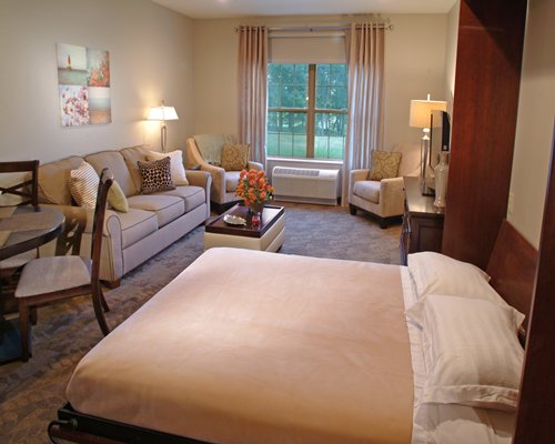 A well furnished living room with a television dining area and bedroom.