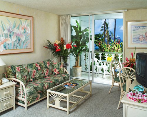 A well furnished living room with a television dining area and balcony.
