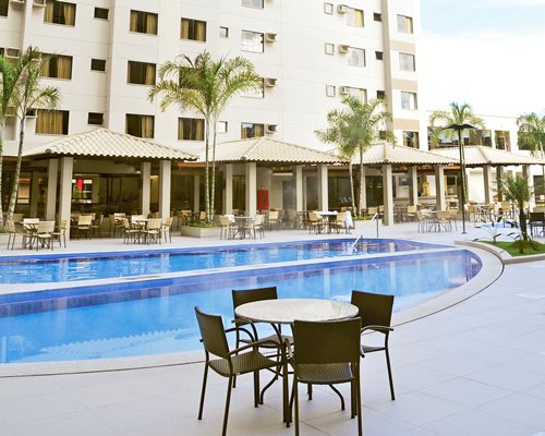 An outdoor swimming pool with patio furniture alongside resort units.