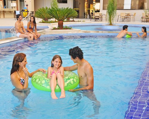 Group of people enjoying in the outdoor outdoor swimming pool.