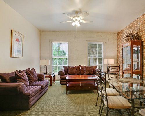 A well furnished living room with a glass top dining area.