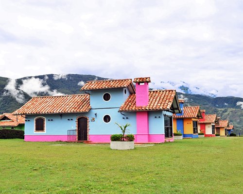 An exterior view of the resort units surrounded by mountains and well maintained lawns.