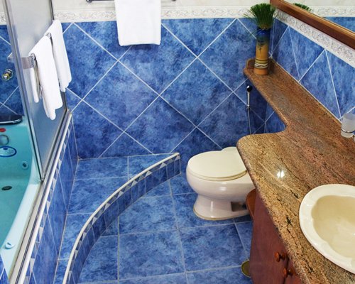 A bathroom with bathtub shower and a single sink vanity.