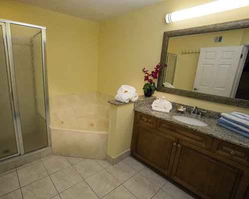 A bathroom with bathtub shower and a single sink vanity.