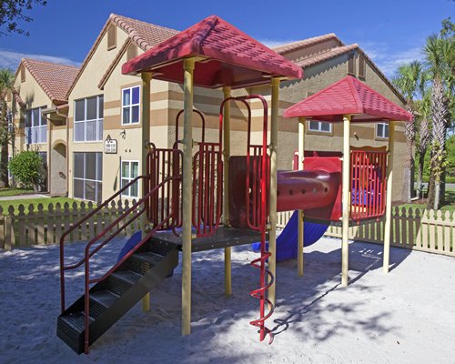 An outdoor playscape alongside multi story resort units.