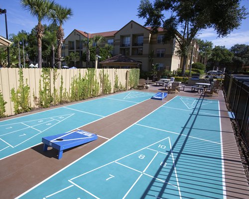 View of outdoor shuffleboards alongside the resort with the trees.