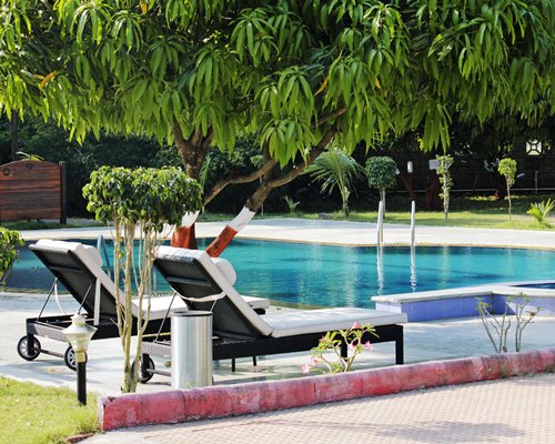 An outdoor swimming pool with chaise lounge chairs.