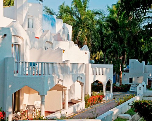 An exterior view of a multi story resort unit with alongside trees.