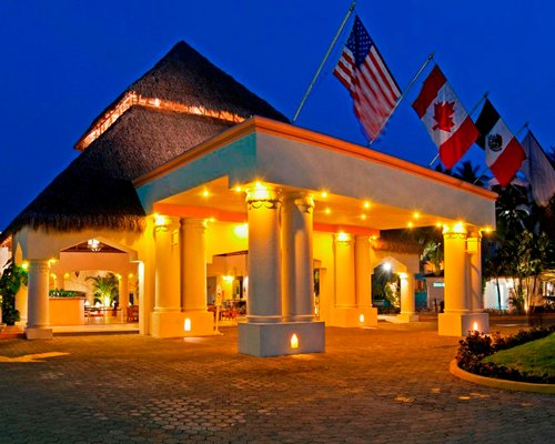An exterior view of a resort unit with flags at night.