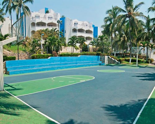 An outdoor basketball court alongside multi story resort units.