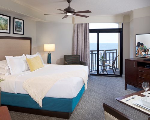 A well furnished bedroom with a balcony.