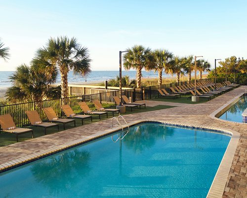 Two outdoor pools alongside multi story resort units.